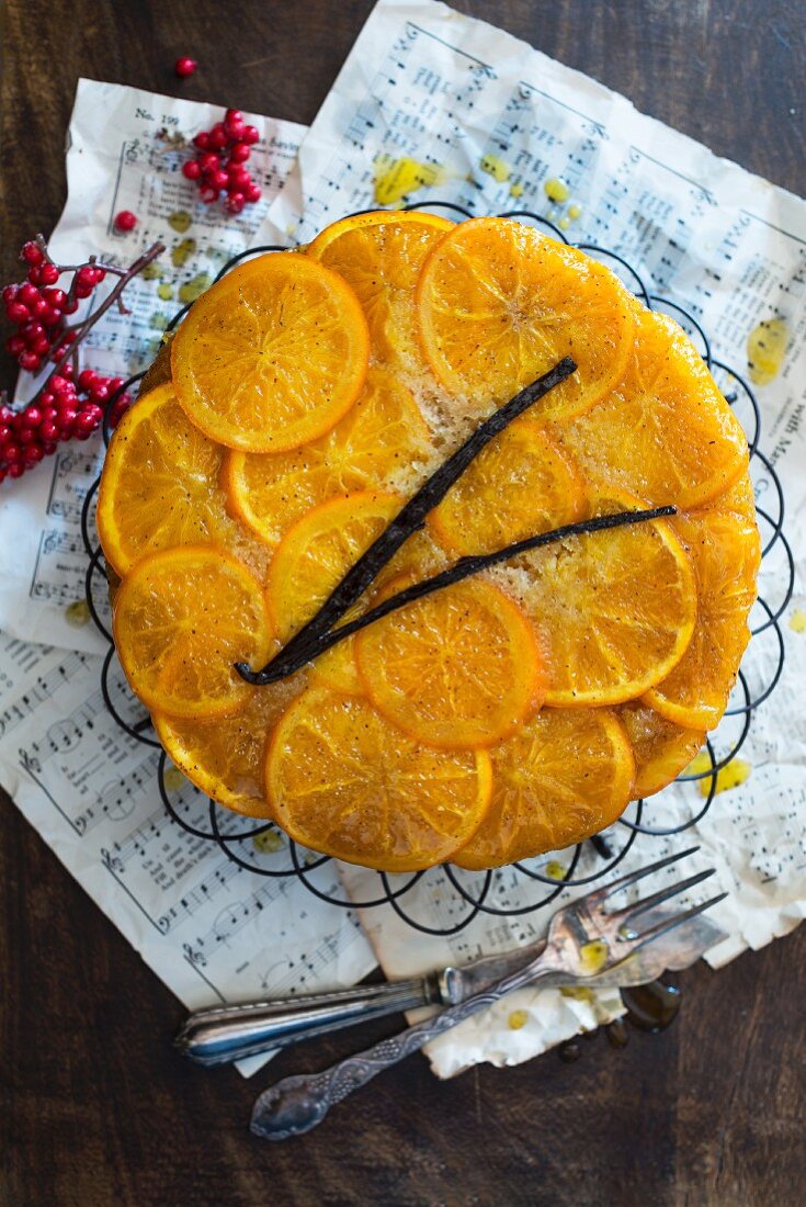 An orange cake on a wire cooling rack