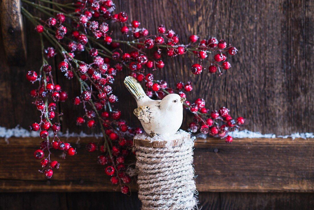 Christmas arrangement of bird ornament and branches of berries