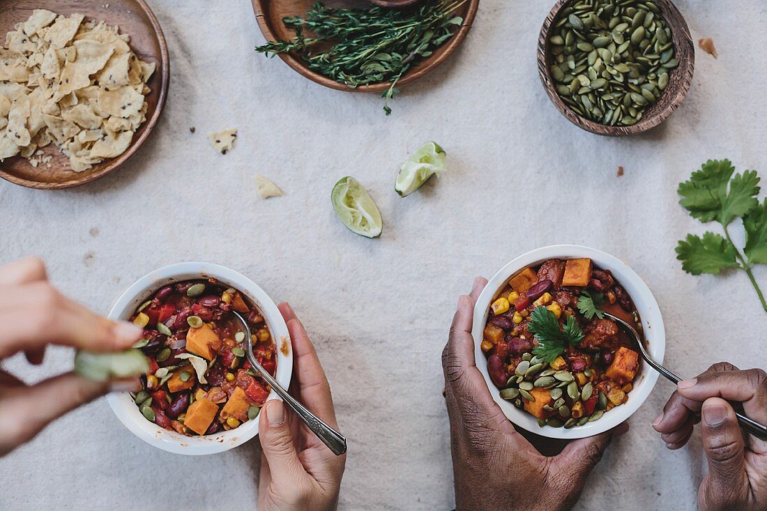 Two people eating sweet potato and corn chocolate chili