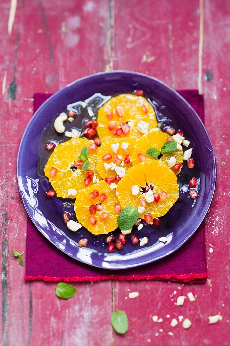 Vegan orange salad with pomegranate seeds and cashew nuts