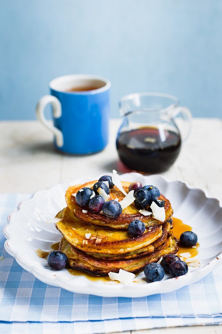 Vegan sweet potato pancakes with blueberries, maple syrup and coconut chips