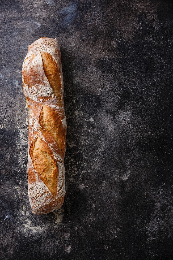 Fresh Baguette bread on dark background copy space