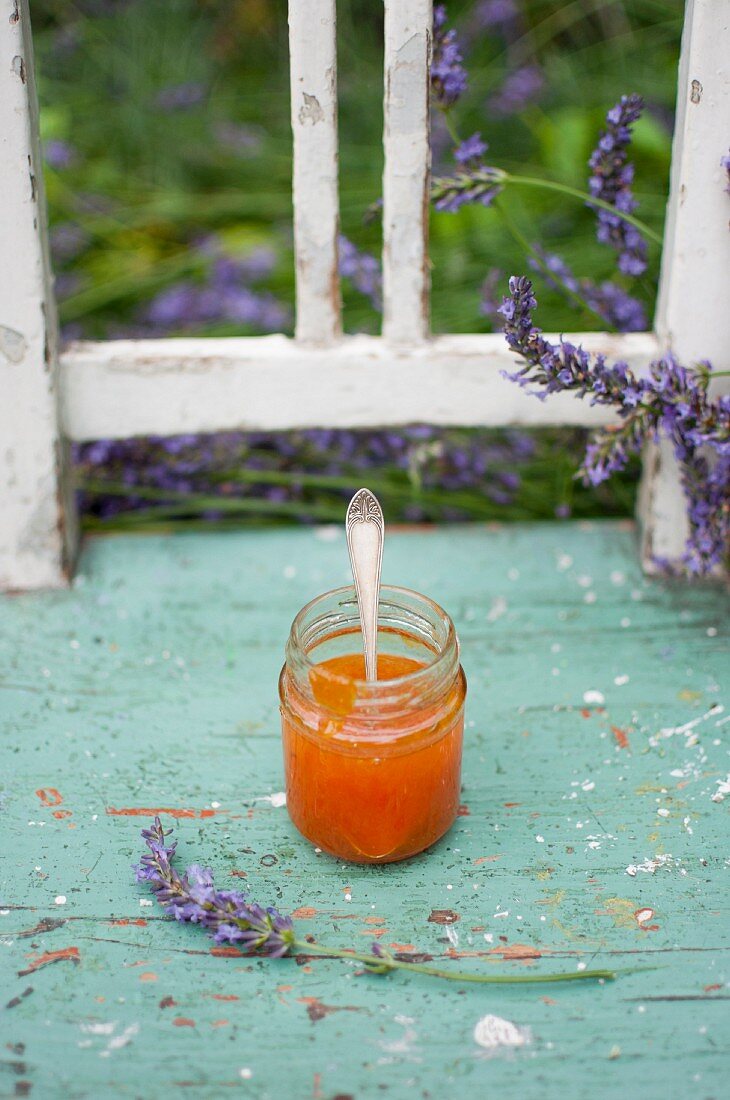 A jar of apricot jam with lavender flowers