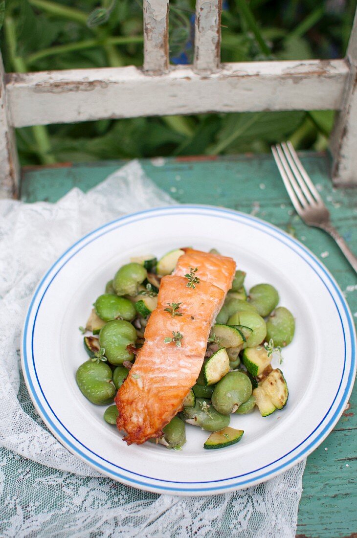 Roasted (oven-baked) salmon served with warm salad made of zucchini, broad beans and lemon thyme