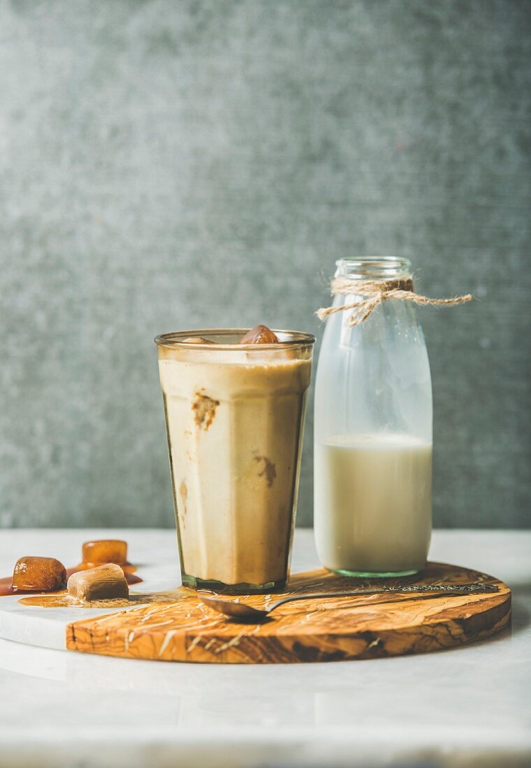 Iced Caramel Latte: Sommerliches Kaffeegetränk mit Milch und Kaffee-Eiswürfel im Glas