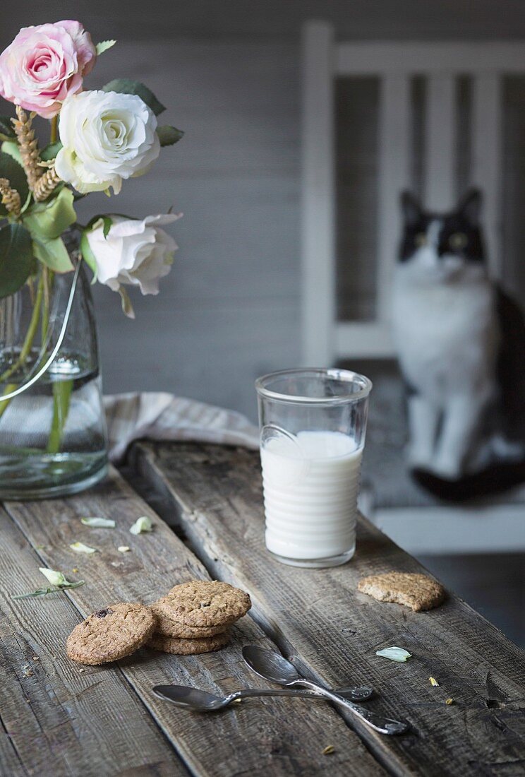 Ein Glas Milch und Kekse auf rustikalem Holztisch