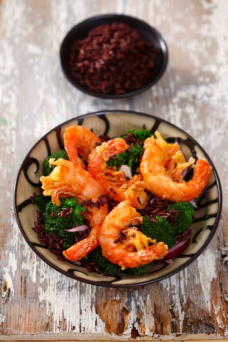 Deep-fried prawns on broccoli and red rice