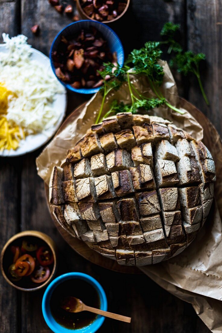 A loaf of dark sourdough bread with ingredients for sandwiches