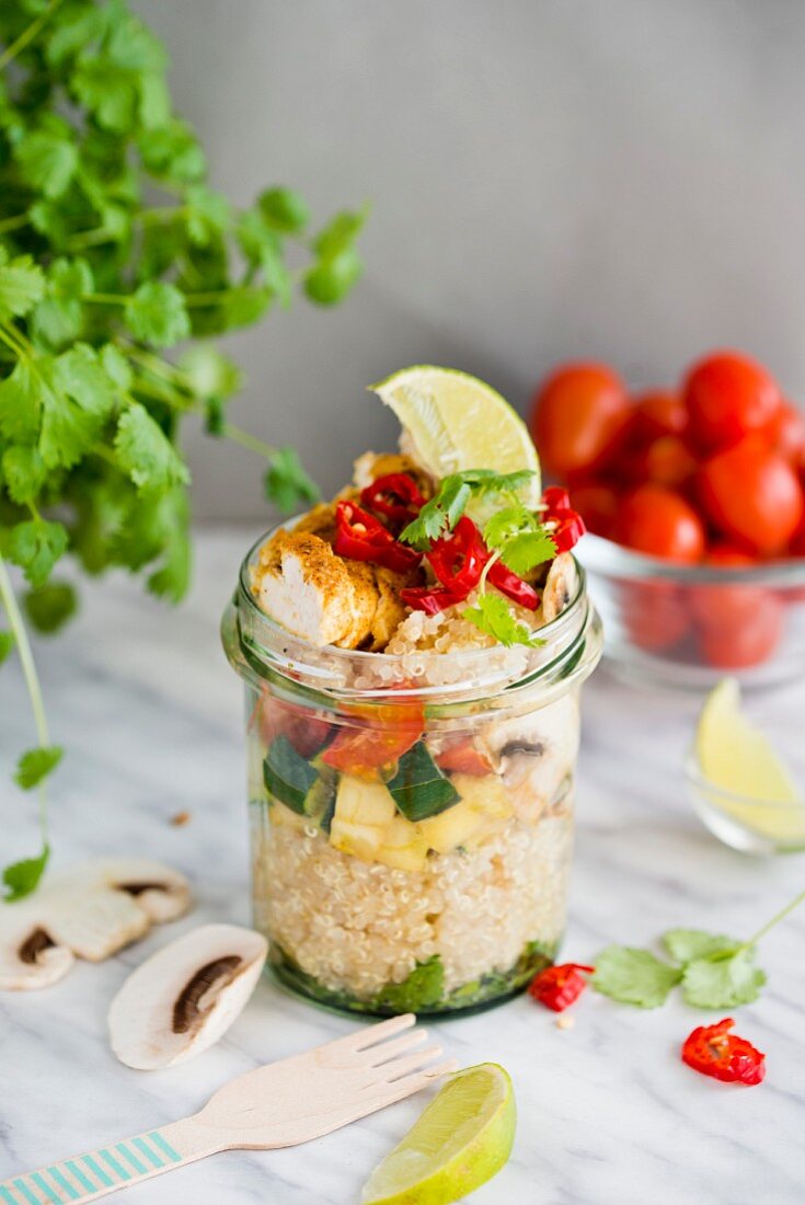 Quinoa chicken curry with courgette, muschrooms and coriander in a glass jar