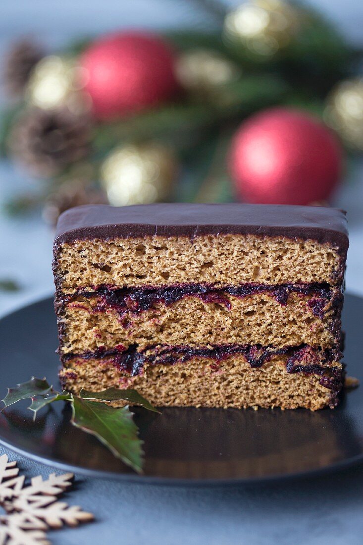 Slice of a gingerbread cake with plum jam and chocolate ganache