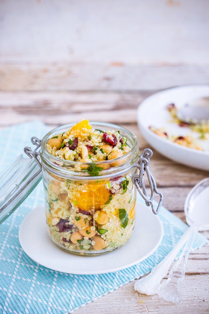 Quinoa salad with orange, chickpeas and lingonberries in a glass jar