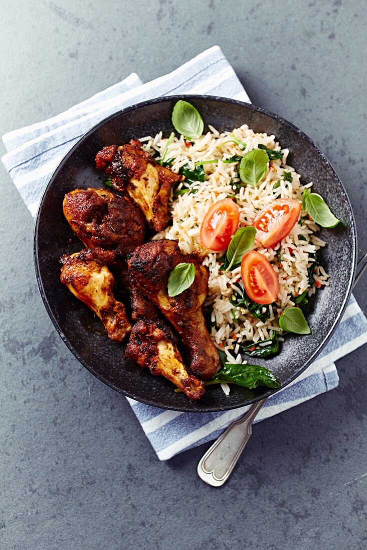 Spicy chicken pieces and basmati rice with spinach