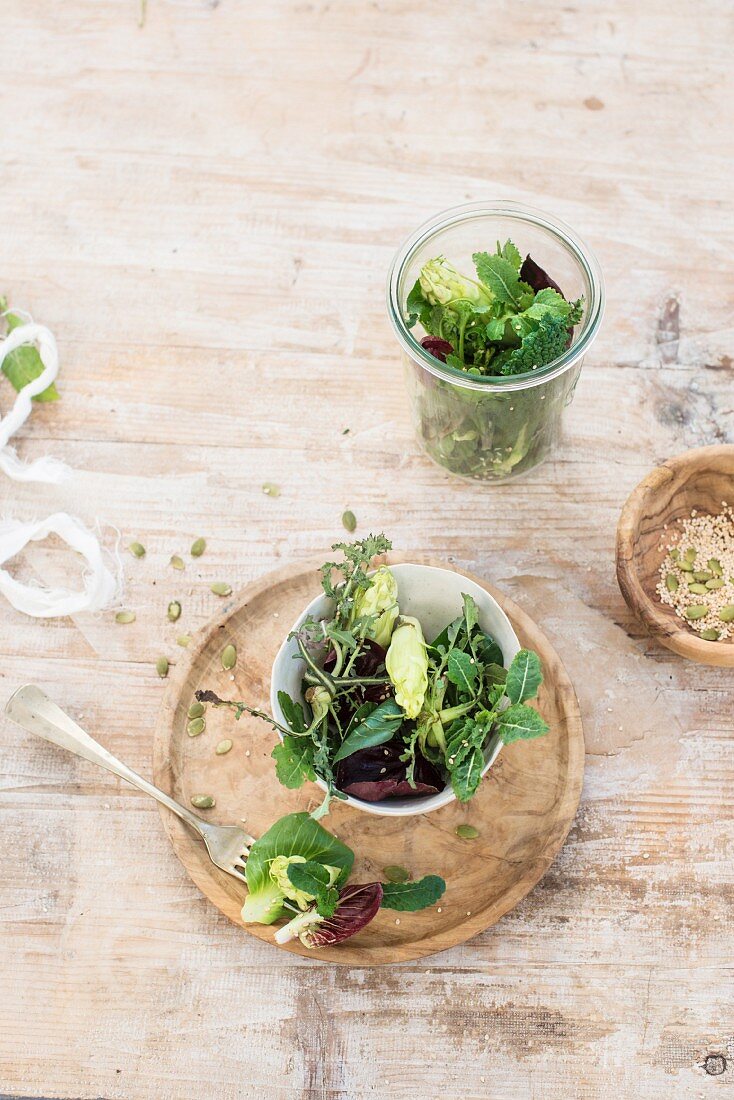 Mixed lettuce leaves in a small bowl and glass