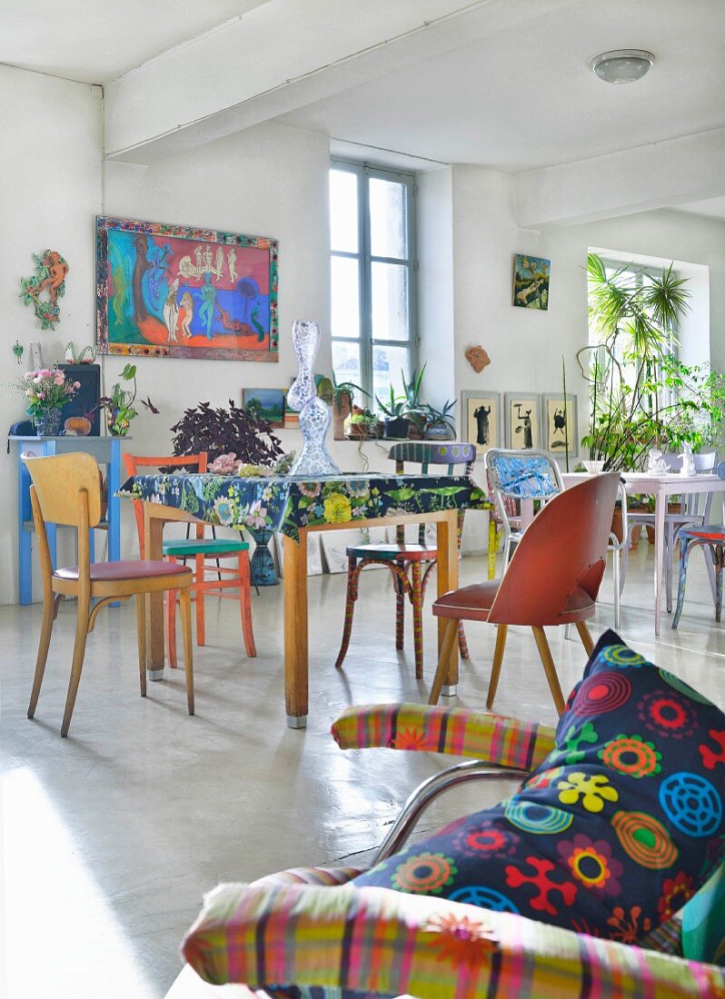 Tables and various chairs in artistic loft apartment