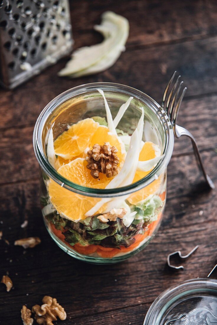 Veganer Salat mit Weisskohl, Karotten, Blattsalat, Fenchel, Orangen und Walnüssen im Glas