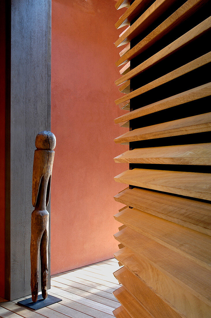 Wooden sculpture against wall and walls with different surfaces