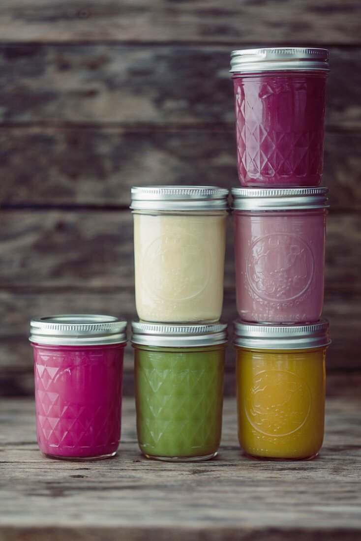 Glass jars of different coloured smoothies