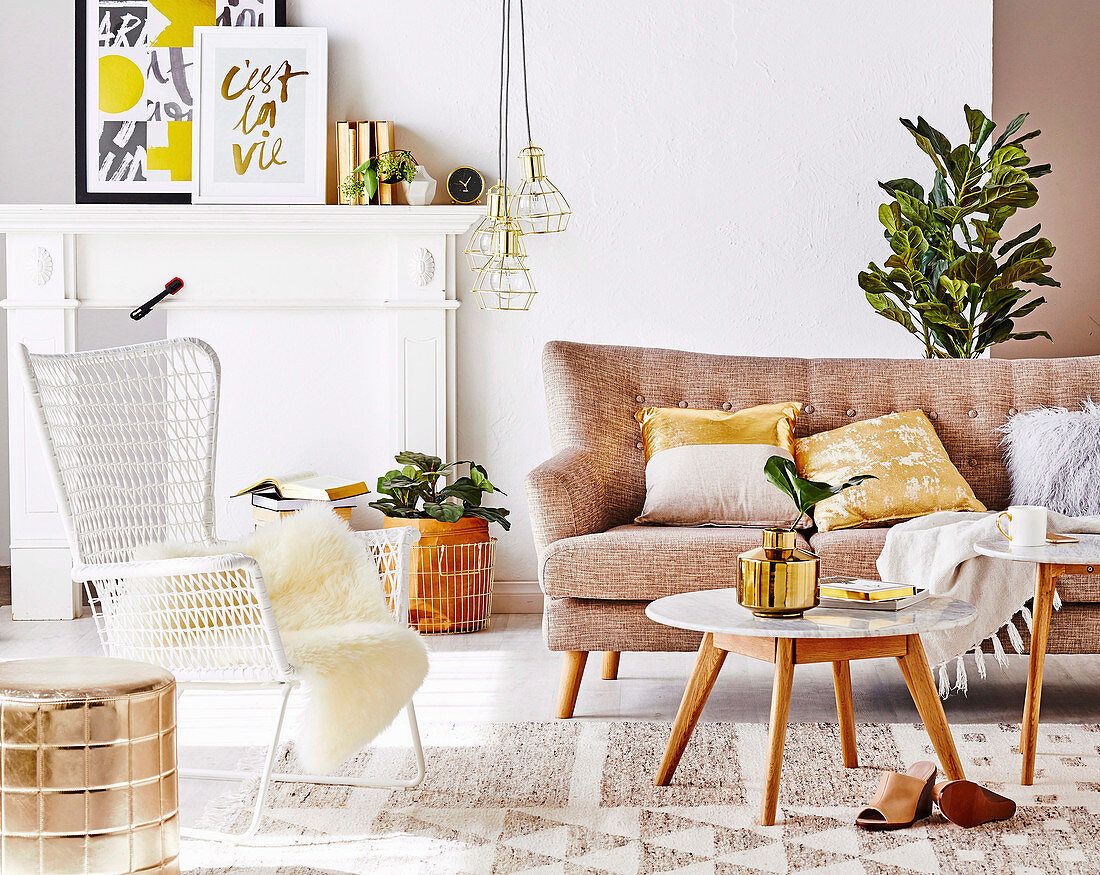 Sofa, Coffeetable und Outdoor-Stuhl im Wohnzimmer mit goldfarbenen Accessoires