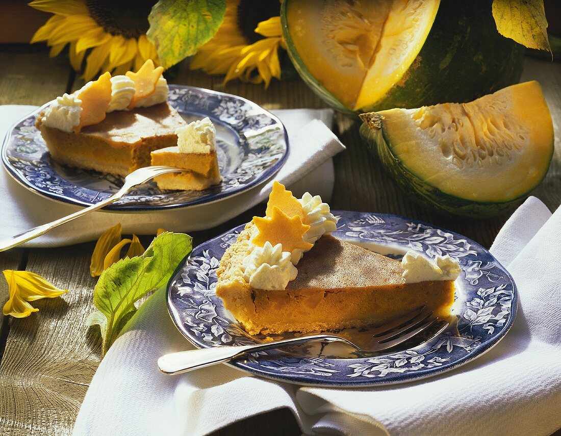 Two pieces of pumpkin pie on plates