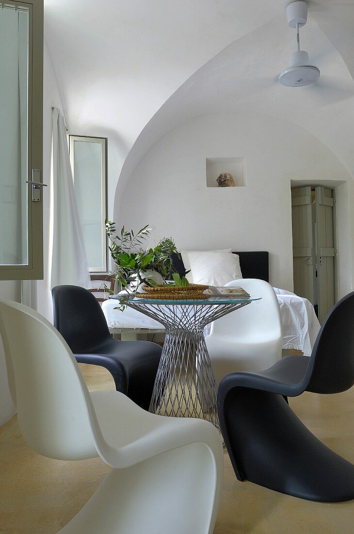 Black and white Panton chairs at round table with glass top in period interior