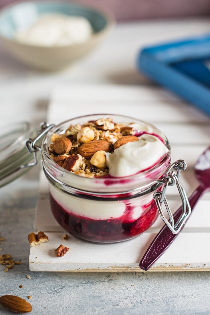 Fruit compot and greek yoghurt with cinamon toasted oats and nuts for breakfast on a go