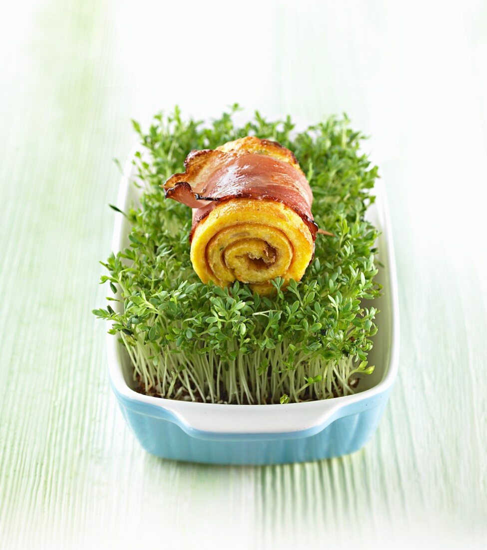 A rolled pancake with bacon on a bed of cress for Easter