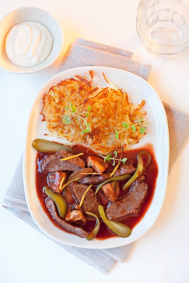 Beef stroganoff with potato rosti, gherkins and mushrooms in red wine sauce