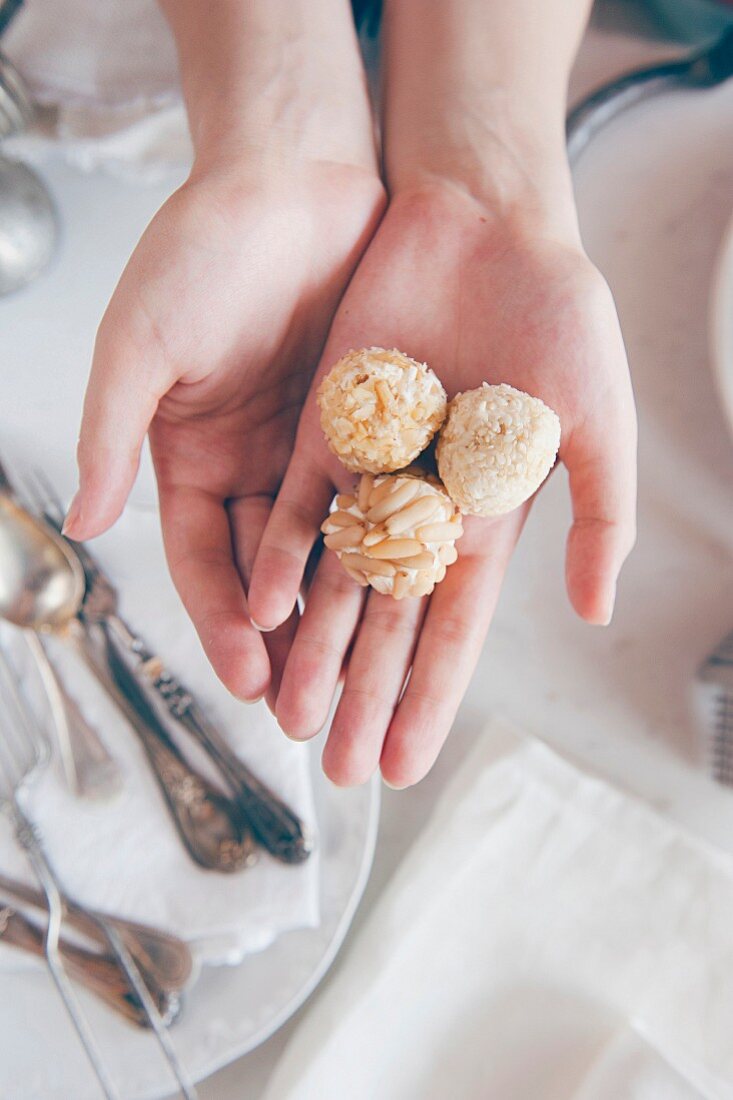 Women's hands holding homemade chocolate truffles (Italy)