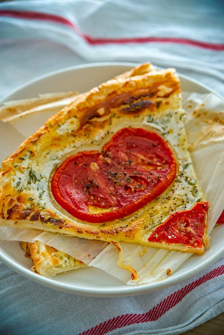 Stücke einer Käsetarte mit Tomaten