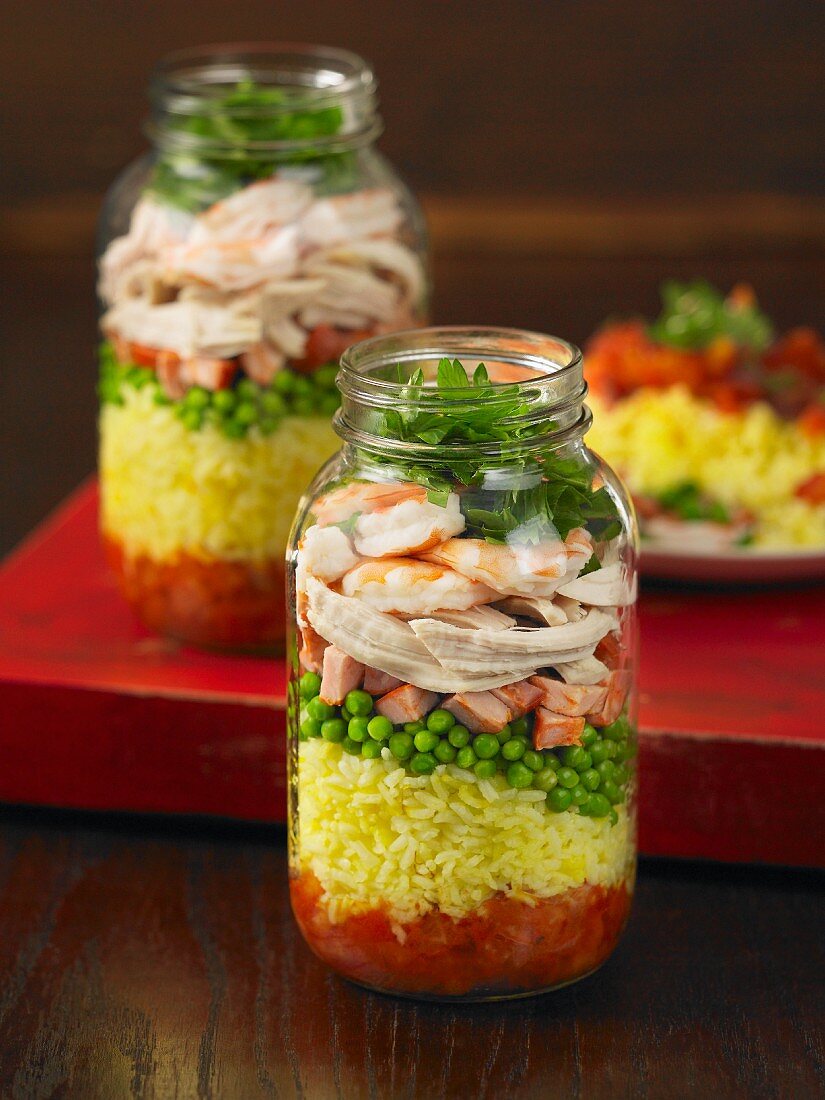 Layered paella in a glass jars