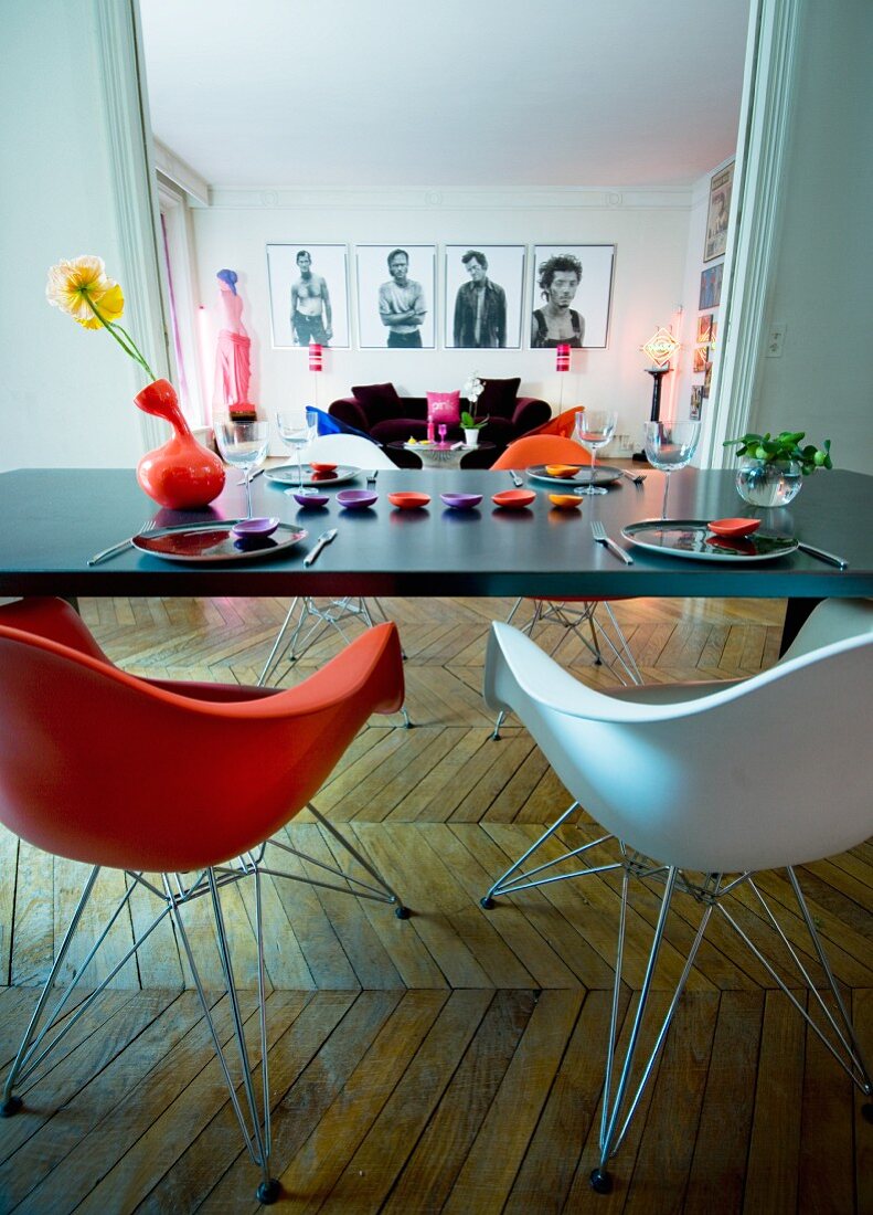 View from dining table into colourful living room with herringbone parquet floor