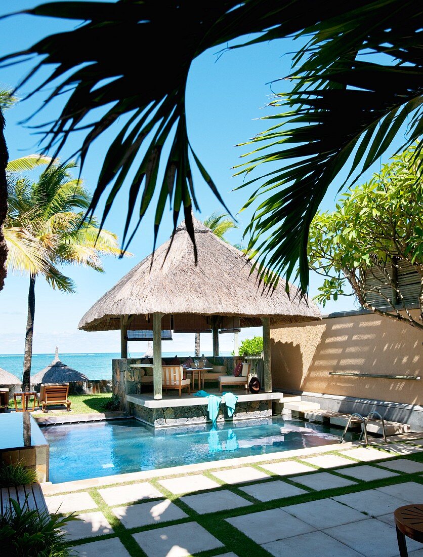 Thatched pavilion next to pool with sea view