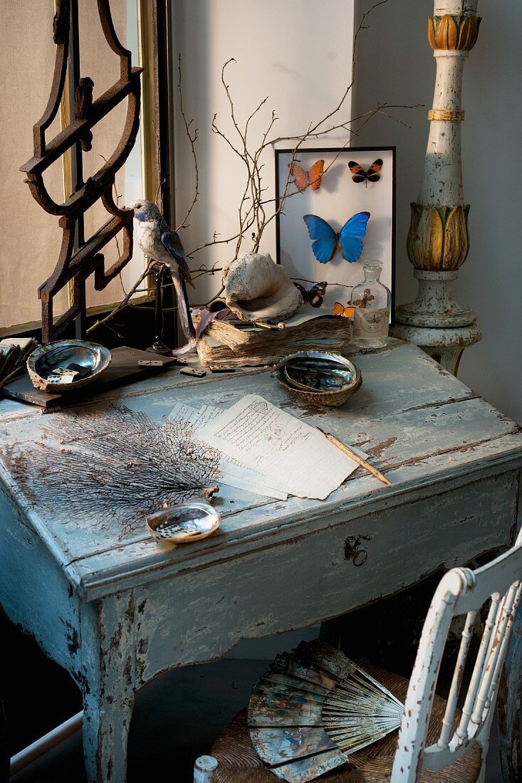 Vintage arrangement of desk, writing paper and framed mounted butterflies