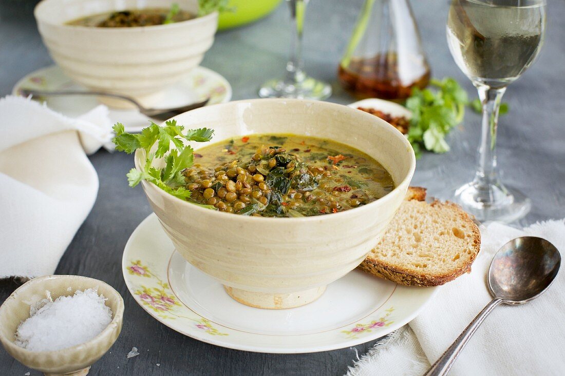 Green Lentil Coconut Soup in ceramic bowls served with bread and white wine
