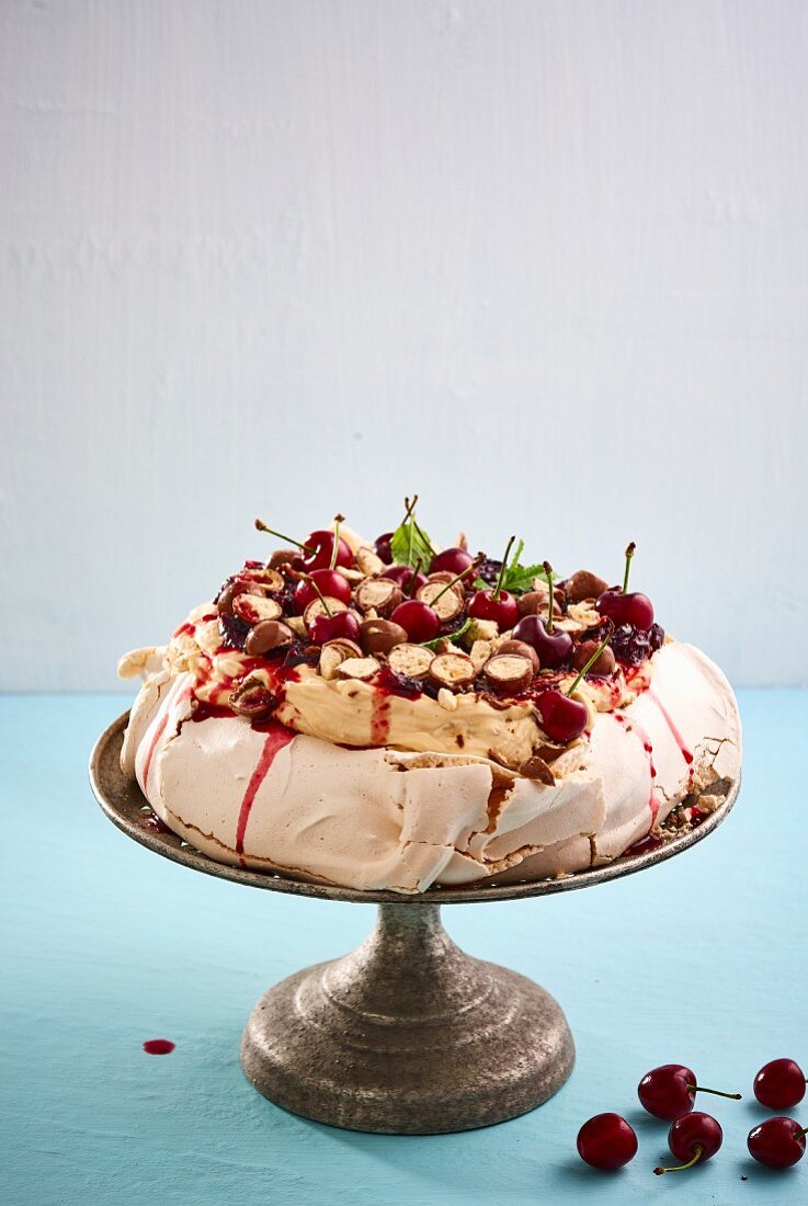 Pavlova mit Karamell-Mascarpone und Kirschsauce auf Tortenständer