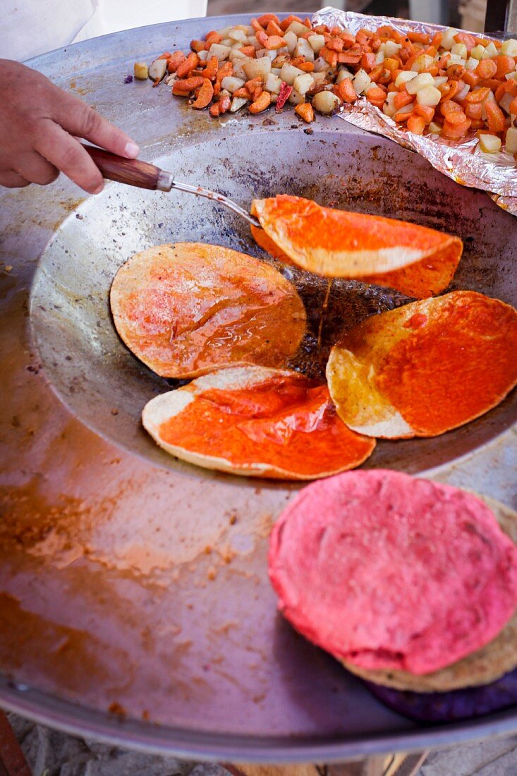 Hand wendet frische Tortillas in der Pfanne