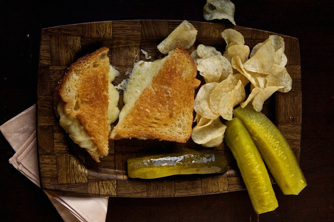 Grilled cheese sandwich with chips and pickles