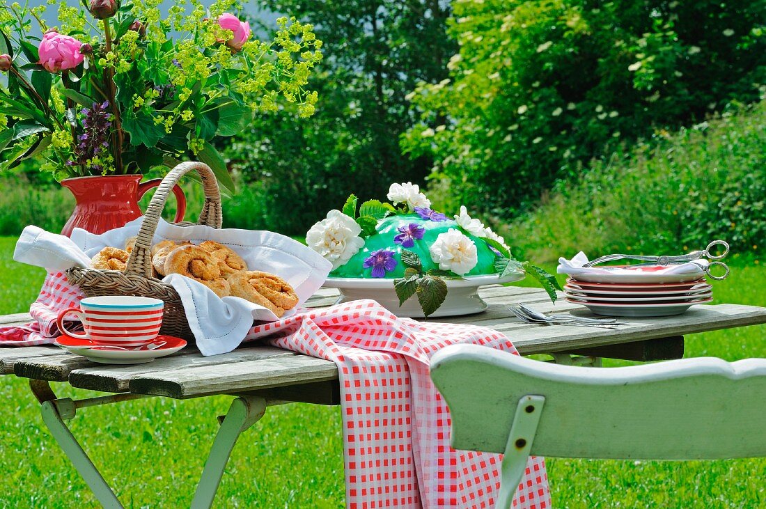 Zimtschnecken und Marzipantorte auf Gartentisch