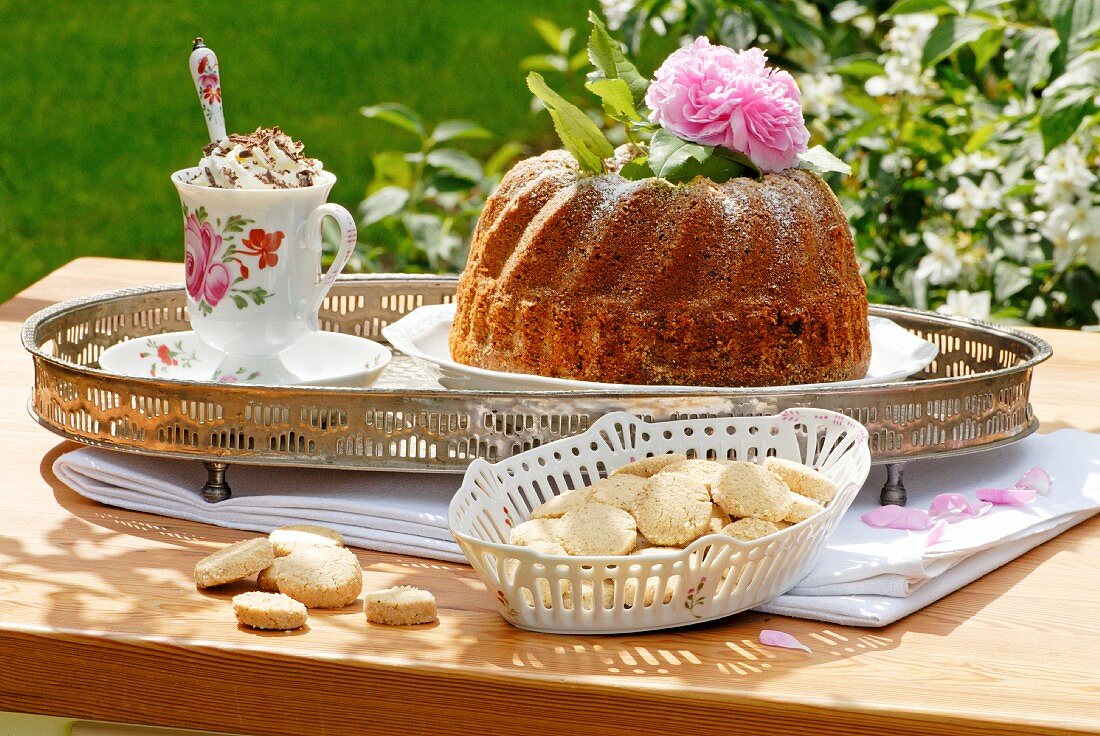 Heidesand biscuits, a gugelhupf and cup of coffee with cream on a silver tray