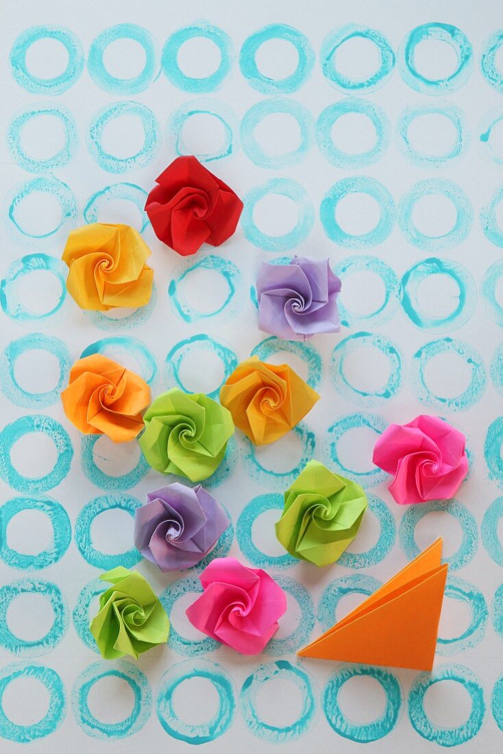 Paper roses on paper with pattern of hand-stamped circles