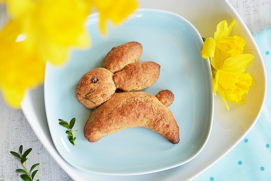A yeast bread Easter bunny with daffodils and beech sprigs