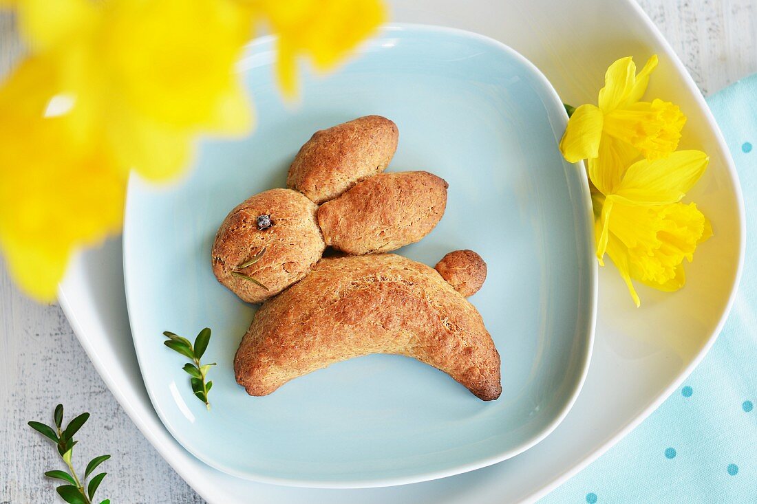 Osterhase aus Hefeteig mit Narzissen und Buchsbaumzweigen