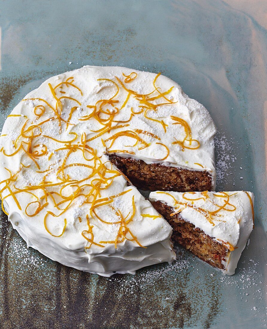 A carrot cake with carrots, apple, nuts and orange