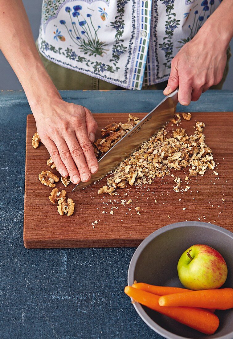 Walnuts being chopped on a wooden board