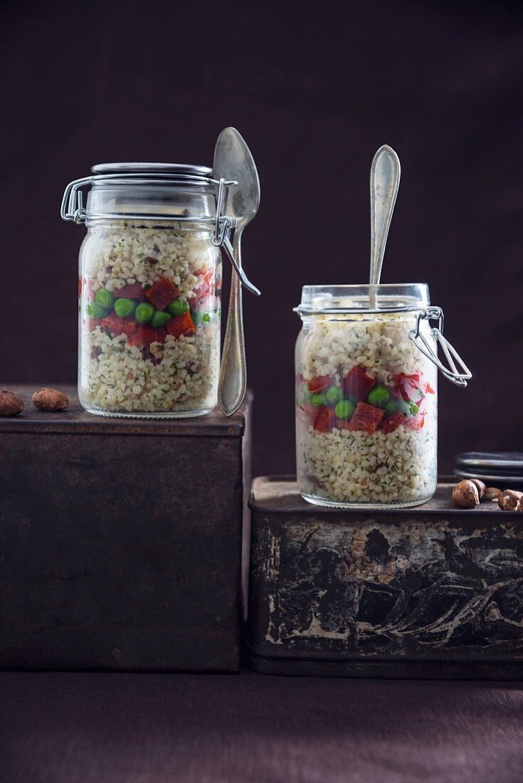 Bulgur wheat salad with hazelnuts, peppers and peas in glass jars