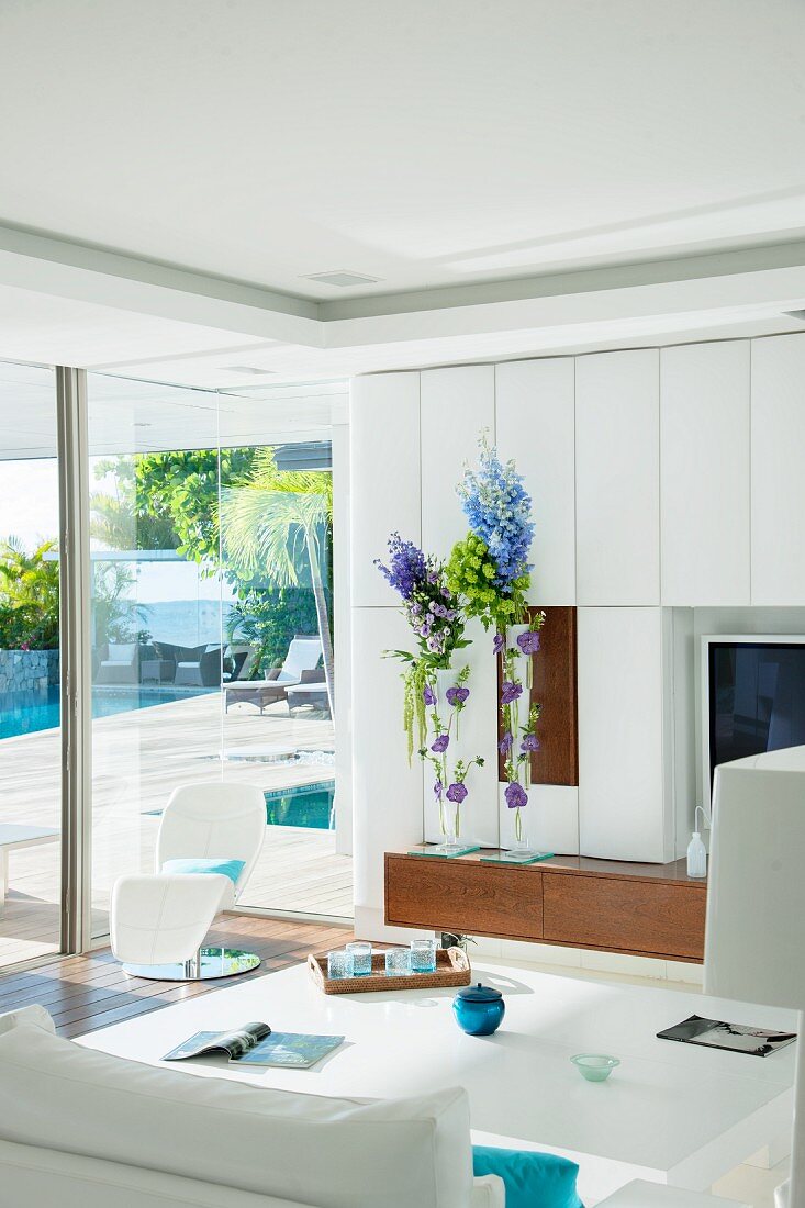 White modern living room with panoramic window leading to terrace