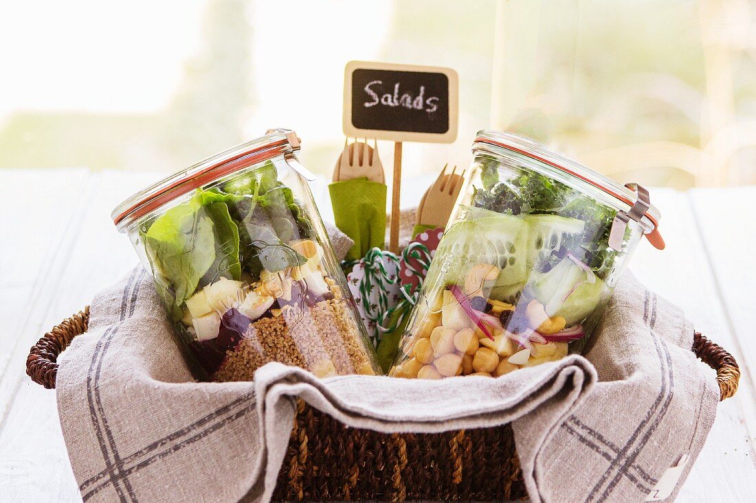 Zwei Salate in Gläsern mit Holzbesteck auf einem Brunchbuffet