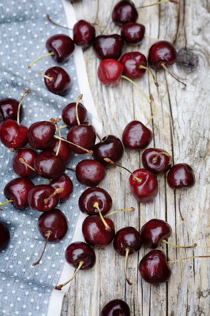 Cherries scattered on a wooden table