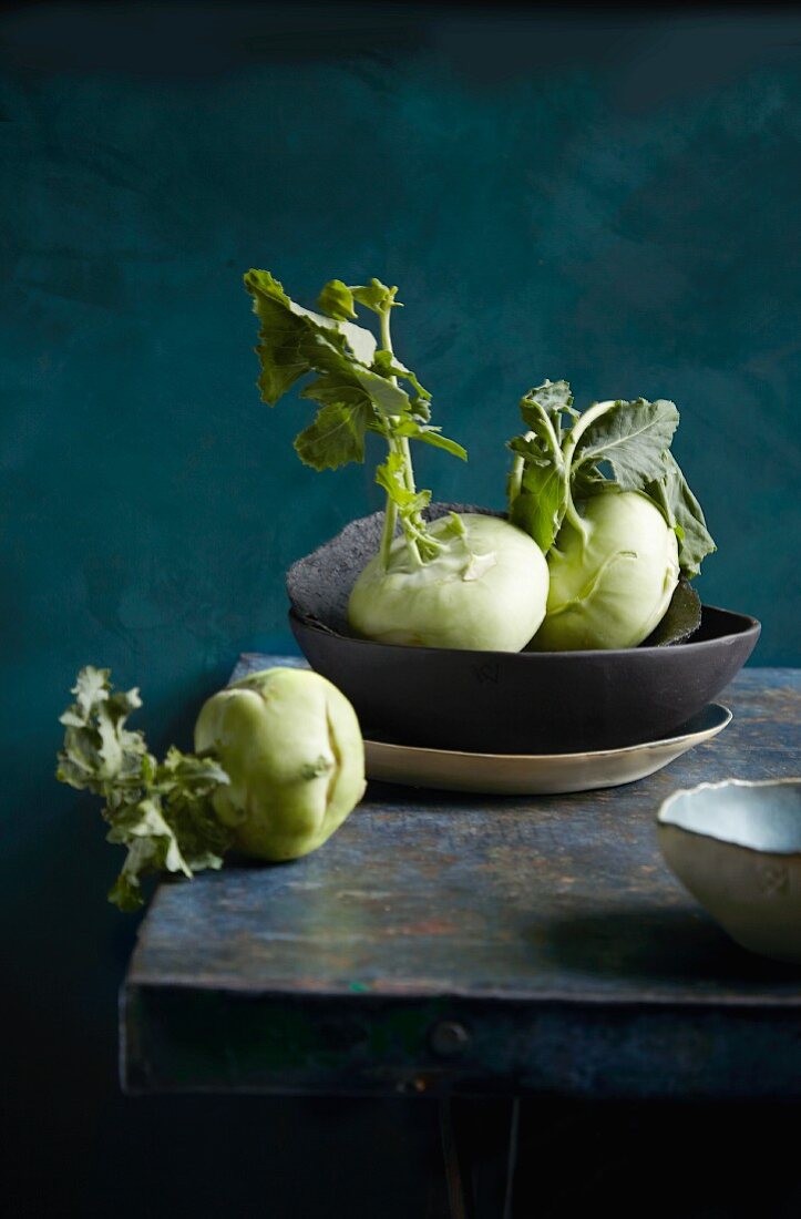 Kohlrabi in a bowl and on a wooden table