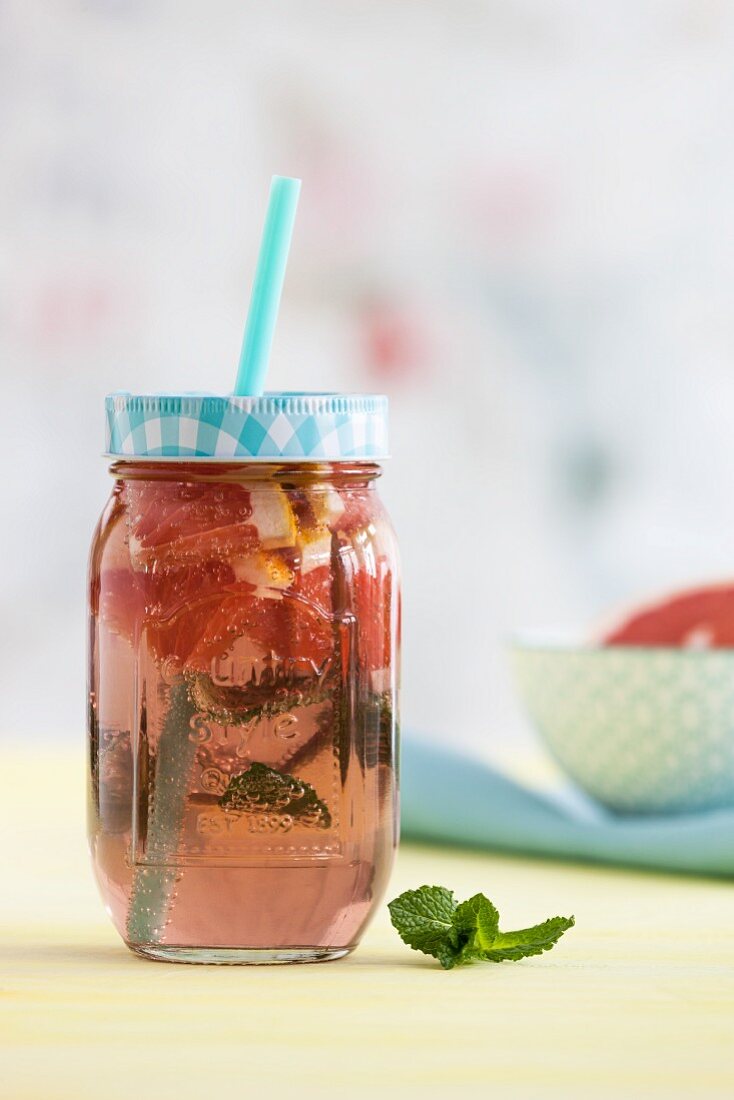Pink grapefruit lemonade with mint in a glass jar